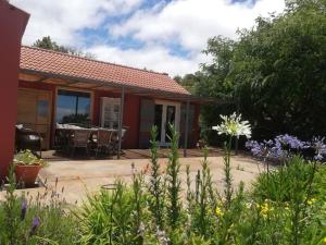 a house with a patio and flowers in front of it at Ferienhaus Finca Sonrisa in Puntagorda