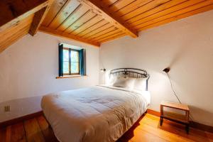 a bedroom with a bed in a room with a window at La Maison Ricard - 4 chambres - 12 personnes in Saint-Férréol-les-Neiges +16 photos