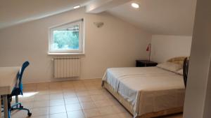 a bedroom with a bed and a desk and a window at Apartma Viva in Ankaran +16 photos