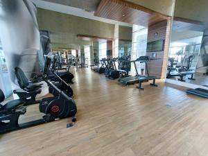una palestra con una fila di tapis roulant e cyclette di O mais lindo 2 dorms no Unlimited Ocean Front 1312 a Santos