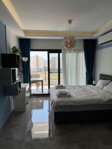 a bedroom with a bed and a large window at Schönes Apartment mit Luxus-Design auf Nordzypern, in Caesar Resort Marcellus 52 in İskele
