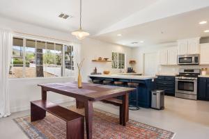 a kitchen with a wooden table and blue cabinets at Bonanza in the Desert - Pool, Hot Tub, Grill home in Yucca Valley
