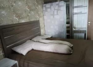 a bed with white pillows on it in a room at Room at parkview bintaro in Jakarta