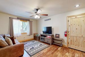 a living room with a couch and a flat screen tv at Serenity at Northwoods in Truckee