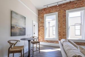 a living room with a brick wall and a table and chairs at Southern Exposure at The Brent Lofts in Pensacola