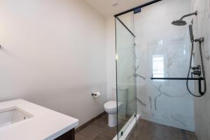 a bathroom with a toilet and a glass shower at Southern Exposure at The Brent Lofts in Pensacola +12 photos