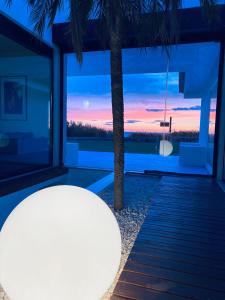 Una habitación con una palmera y vista al atardecer. en Best Beach Front Villa with Heated Pool - Sea La Vie, en Fão