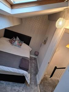 a small bedroom with a bed and a chandelier at Cosy 19th century town-house in Clitheroe