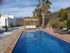 a swimming pool with a gazebo next to a house at Casa los Limones Torrox in Torrox