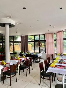 jadalnia ze stołami, krzesłami i oknami w obiekcie Hotel Echo w mieście Cedzyna