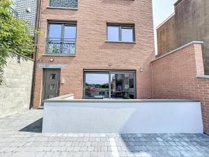 a brick building with a white wall in front of it at Residence pascalino in Ans