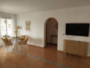 a living room with a table and a flat screen tv at Casa los Limones Torrox in Torrox