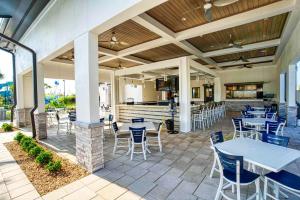 a patio with tables and chairs and a bar at Stunning Home wPrivate Pool, minutes from Disney in Davenport