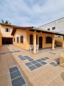 a house with a courtyard with a table and a building at Casa com piscina in Bertioga