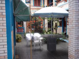 a table and chairs with an umbrella on a patio at Pousada Riacho Doce in Caraguatatuba