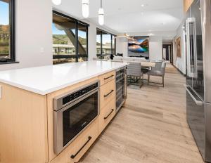 cocina con encimeras blancas y comedor en ONE Riverfront #402 - Avon, en Avon