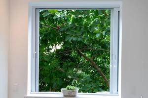 a window with a view of a tree at Apto Copacabana 200 da Praia - Suíte + Lava&Seca in Rio de Janeiro