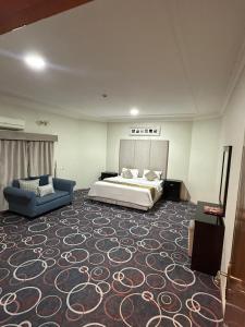 a bedroom with a bed and a couch in a room at اجنحة ارتياد للشقق المخدومه in Abha