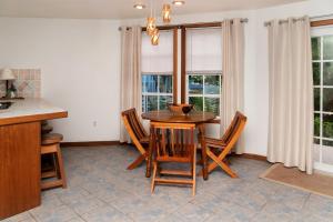 a dining room with a table and chairs and windows at White Sands Cove E01-Partial Ocean View 2 BR by Stay Floreo in San Pedro
