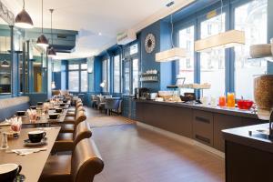 um restaurante com paredes azuis e uma fila de mesas em Appia La Fayette em Paris