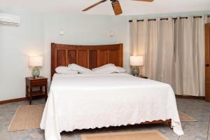 a bedroom with a large white bed with two lamps at White Sands Cove E01-Partial Ocean View 2 BR by Stay Floreo in San Pedro +41 photos