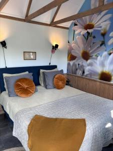 a bedroom with a bed with flowers on the wall at Bed en Brochje De Oase in Sweagerbosk 