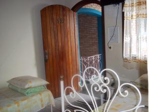 Zimmer mit einer Tür, einem Bett und einem Tisch in der Unterkunft Pousada Riacho Doce in Caraguatatuba