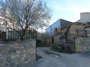 an old stone house with a gate and a building at Casa El Cantón in La Cuba