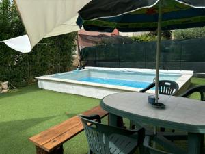 un tavolo con ombrellone accanto alla piscina di Dante alighieri rooms a Villa Colle Onorato