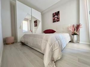 a white bedroom with a large bed and a mirror at Relais Verde Casa in Trecastelli