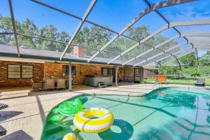 鲁兹Lutz Home with Game Room 7 Mi to Adventure Island!的一个带玻璃屋顶的室内游泳池
