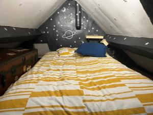 a bedroom with a bed with a black and yellow comforter at Harlequin Cottage in Llangernyw
