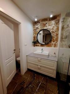 a bathroom with a sink and a mirror at Blue Shutter Garden Studio in Komiža