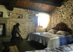 a bedroom with two beds and a stone wall at Locanda La Campana in Agnone
