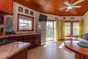 a large kitchen with a refrigerator and a table at White Sands Cove G04- Partial Ocean View 1 BR by Stay Floreo in San Pedro