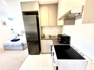 a kitchen with a refrigerator and a bed in a room at Spectacular Modern, Private Apartment,15 Mins To Central London in Hendon +14 photos