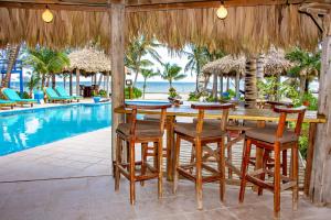 a dining area with a table and chairs next to a pool at White Sands Cove L01-Garden view 1 BR by Stay Floreo in San Pedro
