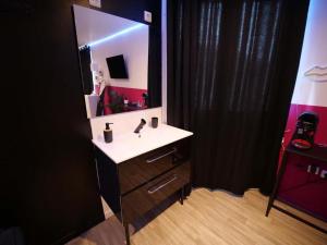 un bagno con un lavandino e un grande specchio di Red Room - Olympe Suites & Spa Lille, Croix, Roubaix a Croix