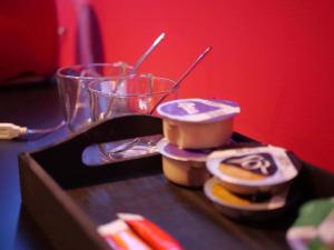 un tavolo con un contenitore di cibo e un bicchiere di Red Room - Olympe Suites & Spa Lille, Croix, Roubaix a Croix Altre 11 foto