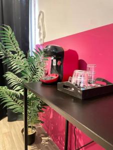 un telefono su un tavolo accanto a una pianta di Red Room - Olympe Suites & Spa Lille, Croix, Roubaix a Croix