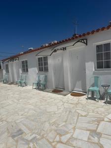 a building with chairs and a table in a patio at Casa da Calma - GUESTHOUSE in Alandroal