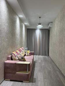 a living room with a pink couch in a room at Home M&M in Kutaisi