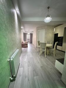 a kitchen and living room with a table and chairs at Home M&M in Kutaisi