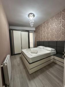 a bedroom with a large bed and a chandelier at Home M&M in Kutaisi
