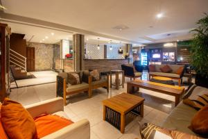 a living room with couches and tables at Hotel Experience João Fernandes in Búzios