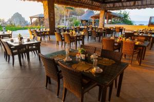 a restaurant with tables and chairs and a view of the ocean at Coral Blue Huatulco All Inclusive in Santa Cruz Huatulco
