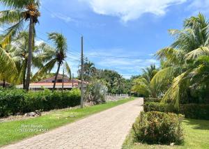 a brick road with palm trees and a building at Las Veraneras Villa - Pet Friendly in Acajutla