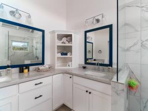 a white bathroom with a sink and a mirror at Sea View Ocean View Villa with Pool by Stay Floreo in San Pedro