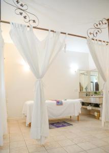 a white room with a bed and a mirror at Hotel Hacienda Los Laureles in Oaxaca City