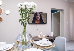 una sala da pranzo con tavolo e vaso di fiori di The Ridge View a Midrand
